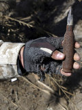 An Engineer Displays a Bullet Found Near a Weapons Cache While on a Patrol