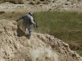 US Army Specialist Climbs Down to the Bottom of a Canal During a Foot Patrol in Iraq
