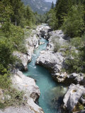 Soca River with Clear Emerald Water Flowing Between Eroded Rocks in Trenta Valley in Summer