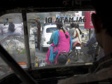 Women Riding on Back of Motorcycles in Heavy Traffic Viewed from Inside a Motor Rickshaw