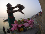 Woman Pouring Water Over Flowers on an Altar as a Religious Ritual  Varanasi  India