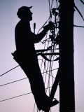 Silhouette of Engineer Working up a Telegraph Pole  East Sussex  England  United Kingdom