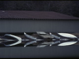 Canoes Reflected in Water at a Boat Landing
