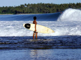 Young Local Boy on Reef Heading out for Afternoon Surf  Lagundri Bay  Indonesia