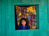 Little Girl in the Window of Her Brightly Painted House  Ciudad Melchor de Mencos  Guatemala