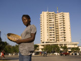 Girl Selling Peanuts on Metical Square  with Highrise Building Behind  Beira  Sofala  Mozambique