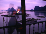 Local Man Lights Pipe Overlooking Net Farms and Karst Formations  Ko Panyi  Phang-Nga  Thailand