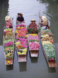 A Group of Four Women Market Traders in Boats Laden with Fruit and Flowers  Thailand