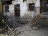 Rusty Satellite Dish and a Rickshaw Cart and Trash Outside a House  Qinghai  China