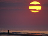 Person Silhouetted on the Beach at Sunrise