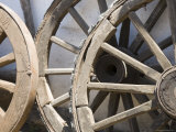Old Wooden Wagon Wheels Leab against a Whitewashed Wall
