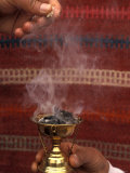 Two Hands Burn Traditional Spices in Front of a Decorative Cloth in Petra  Jordan
