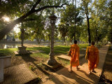 Two Buddhist Monks Walk Along the Siem Reap River at Sunrise  Cambodia