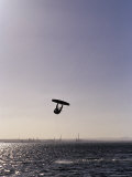 The Silhouette of a Person Kite Surfing  in a Choppy Windswept Bay  Australia