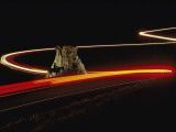 Time Exposure of Cars Speeding Past a Silhouetted Cowboy on Horseback