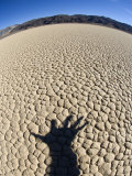Shadow of Hand Reaching Out over Dry Desert Floor  California