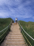 Woman Walks Through Dunes in the National Park on Prince Edward Island  Canada