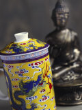 Decorated Teacup with Lid in Front of Statue of Buddha