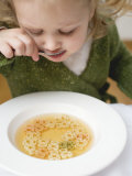 Small Girl Eating Soup with Teddy Bear Pasta