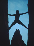 Silhouette of Rock Climber Between Two Rocks