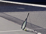 Tennis Racquet Against Net with Ball