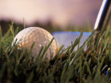 Golf Ball in Ruff with Iron in Background
