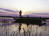 Man Standing in Boat Fishing