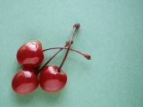 Three Cherries on a Green Background