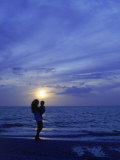 Silhouette of Mother and Child on Beach at Sunset