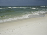 Footprints Along a Sandy Beach with Gentle Surf