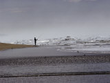 A Fisherman Casts His Line into the Surf