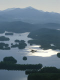 A Floatplane Flies over Long Lake with Mount Marcy in the Background