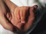 A Close View of a Mother Holding Her Newborn Babys Hand