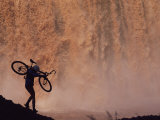 Silhouetted Cyclist Carrying Cycle Past Falls