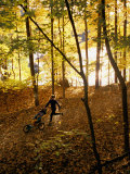 A Woman Pushes a Baby Stroller as She Jogs Through a Wooded Area