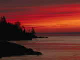 A Bright Red Sky over Lake Superior at Dawn with Silhouettes of the Rocky Coast