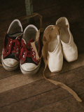 A Pair of Ballet Toe Shoes Rest Next to a Pair of Tennis Shoes