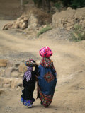 A Yemeni Woman and Child Carrying Bundles on Their Heads