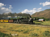 Old Locomotive with Billowing Black Smoke in Hilly Countryside
