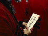 Buddhist Priest Holds Prayer Cards in his Hands