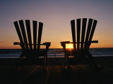 Two Chairs on a Shoreline Facing the Setting Sun
