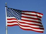 American Flag Blowing against a Blue Sky on the Grounds of the Washington Monument