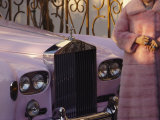 A Woman Wearing a Pink Mink Coat Stands Next to a Pink Rolls Royce