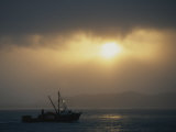 A Fishing Boat Heads out to Sea at Sunrise