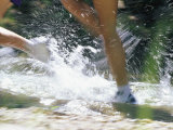 Runners Legs Splashing Through a Creek