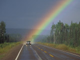 A Car on a Highway Drives Close to a Rainbow