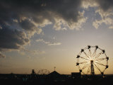 A Ferris Wheel is Silhouetted against the Evening Sky