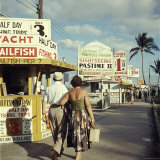 Vacationers Walking by Booths Advertising Boat Tours