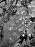 Couple Relaxing on Bank of Seine Near Notre Dame Cathedral During Lunch Hour