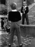 English Boy Using Reflection in Mirror in Foyer of Grand Hotel to Fix His Tie